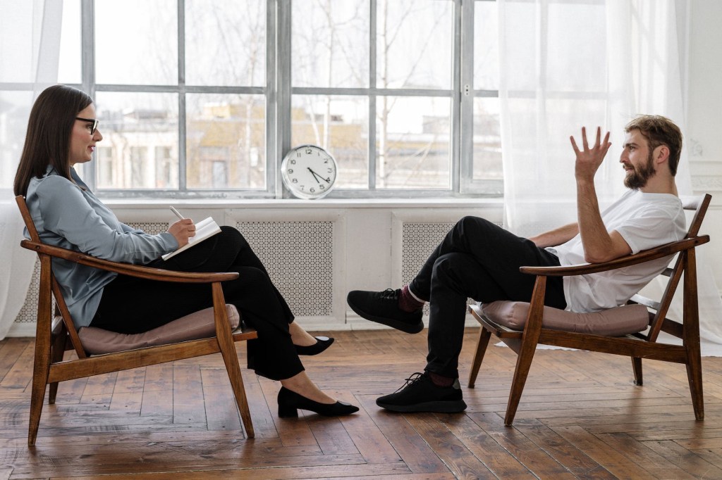 man and woman talking on chairs