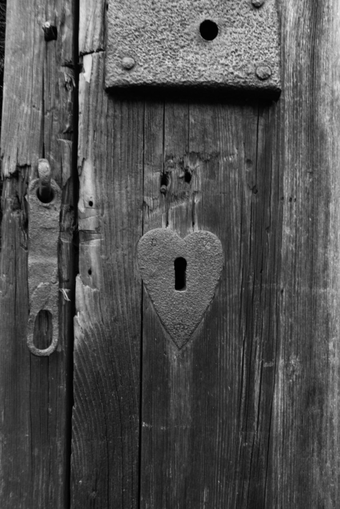 a heart shaped keyhole on an old wooden door